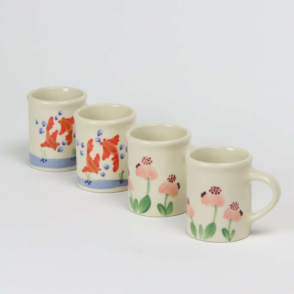 Selection of stoneware pottery Children's Cups in multiple glazes and hand-painted designs.