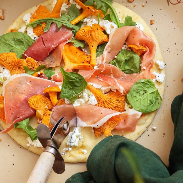 Stoneware pizza stone with flatbread pizza.